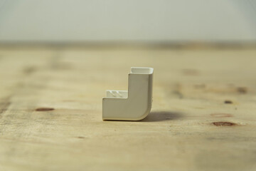 90 degree elbow type electrical connector on wooden background