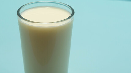 Glass cup served with milk on blue background