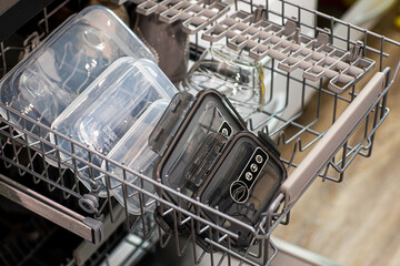 closeup of plastic containers in a dishwasher, in a kitchen indoors