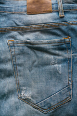 Back pocket of wrinkle blue jeans.