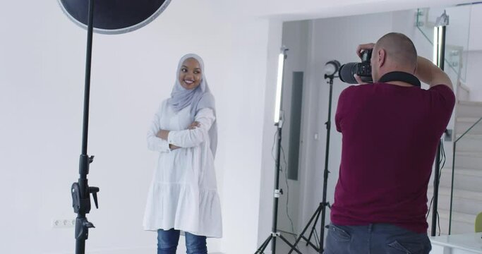 Photographer in photo studio shooting traditional muslim black model