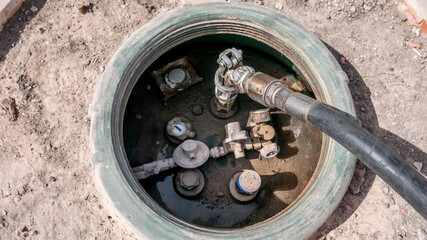 LPG tank refueling performed by a skilled worker with appropriate pipes connected to the truck with pressure gauges and pipes in evidence
