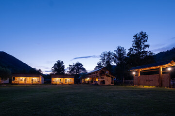 Obraz premium Wooden gate and houses in mountain rustic resort night view