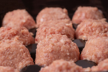 prepared raw meat balls in a black special tray.