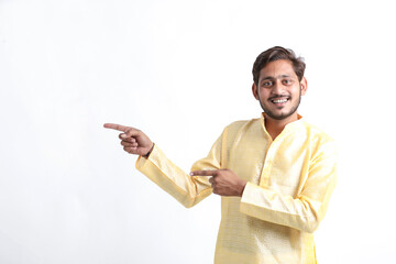Young indian man showing direction on white background.