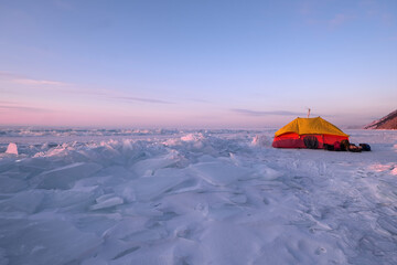 Sunrise winter landscape, tent standing on the ice of frozen Lake Baikal