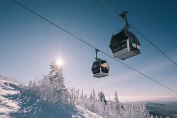 Wall murals Gondolas gondola ski lift in mountain ski resort, winter day, snowy spruce forest