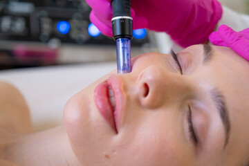 Beautician makes skin care procedure on a  face. Woman in a spa salon on cosmetic procedures for...