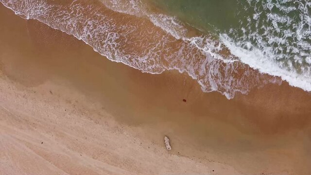 Sea waves on a sandy beach with a drone