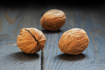 Walnuts lie on a dark wooden table.