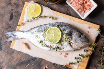 fresh raw dorado fish. dorado fish and cooking ingredients - lime, salt, oil, garlic, thyme and herbs.
