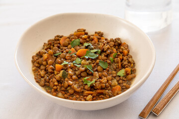 lentils with vegetables in a plate on the dining table. comfort homemade food, vegetarian lentils