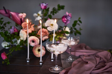 decorated table with flower decorations and white candles on dark grey background