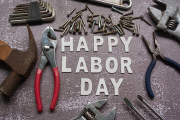 Happy labor day text with many handy tools on grunge grey concrete background