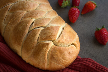 Appetizing sweet bread on a table. Homemade white wheat flour bread on gray textured background. 