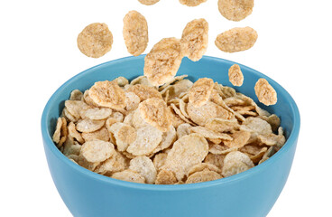 Cornflakes falling into a bowl on a isolated white background. Traditional English breakfast with cornflakes. 
