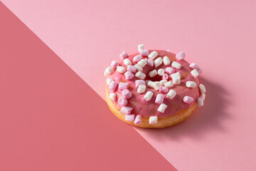 Pink donut with marshmallow topping on two colour background .Sweet minimalist food image. Modern...