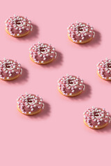 Pink marshmallow donut pattern. Many Donuts on pink vertical background.