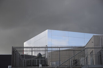 Modern reflective mirror building with clouds