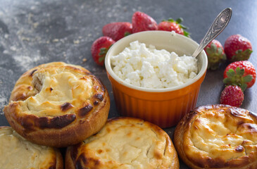 Round scones with cottage cheese on a table. Russian homemade pastry items. Sweet buns top view photo.