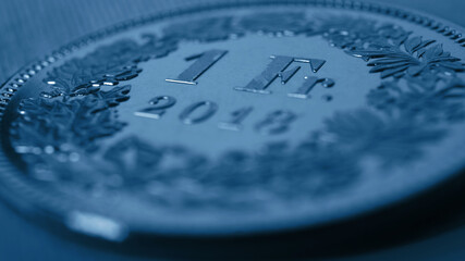 1 Swiss Franc coin close-up. Dark blue background or wallpaper on an economic, business,...