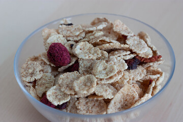 Tarro de cristal con cereales y fruta deshidratada sobre fondo de madera