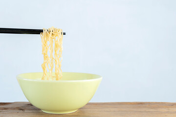 Chopsticks to pickup tasty noodles, selective focus