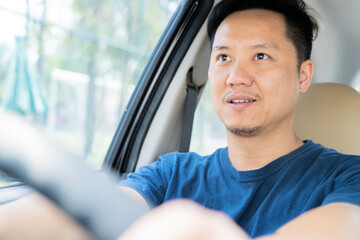 Young handsome asian man driving car to travel.