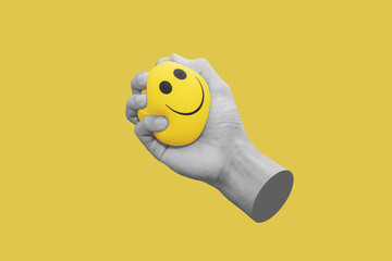 Hand squeeze yellow stress ball, isolated on yellow background - 425001357