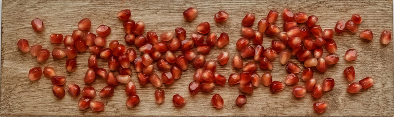 Ripe pomegranate fruit near leaf on dark wooden background top-down copy space