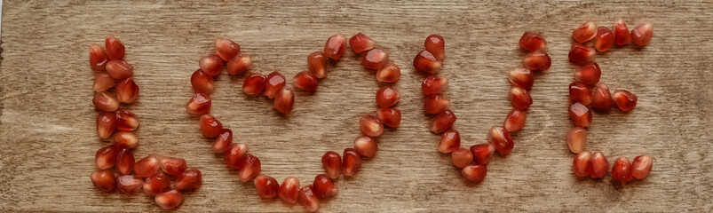 Ripe pomegranate fruit near leaf on dark wooden background top-down copy space