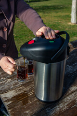 person filling tea from thermos