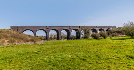 Bright Spring sunshine illuminates the abandoned Helmdon viaduct