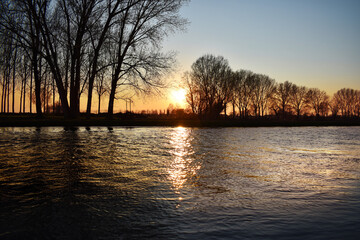 incredible sunset on the Muzza river, lights, colors and reflections surround this breathtaking landscape