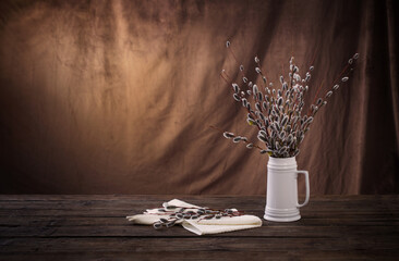 spring willow branches  in  white jug  on brown dark background