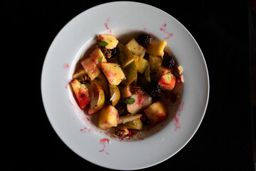 COLOURFUL FRUIT SALAD WHITE DISH ON BLACK 