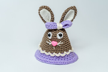 Homemade amigurumi egg warmers crocheted from wool. In different scenes with a white and gray background and on a dining table.