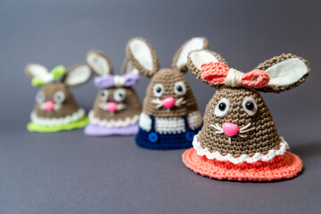 Homemade Amigurumi egg warmers crocheted from wool. In different scenes with a white and gray background and on a dining table.