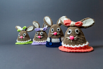 Homemade Amigurumi egg warmers crocheted from wool. In different scenes with a white and gray background and on a dining table.