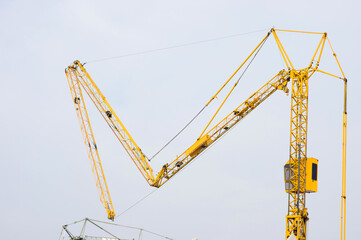 Arm of yellow tower crane fold up at construction site