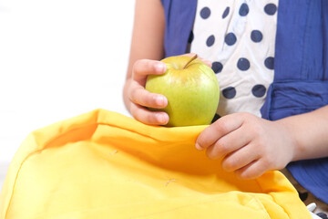 child hand holding green apple on white background 