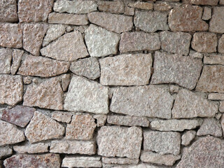 Fragment of a wall lined with stone slabs of a light beige shade
