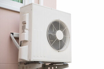 External split wall type of house air conditioner compressor unit installed on the outside of the building.