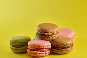 Cake macaron close up on yellow background flavor almond cookies pastel colors.