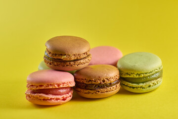 Cake macaron close up on yellow background flavor almond cookies pastel colors.