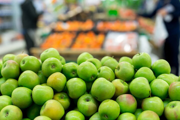 Green and red apples on boxes in supermarket