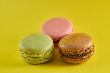 Cake macaron close up on yellow background flavor almond cookies pastel colors.