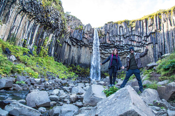 A couple at the beautiful Svartifoss waterfall in Iceland