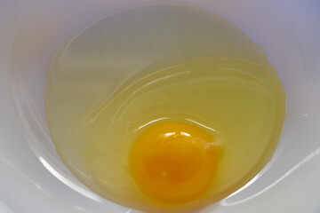 Broken chicken egg in a bowl in the kitchen.