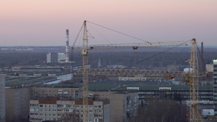 Fototapeta na wymiar Two construction cranes are working at a construction site close-up.